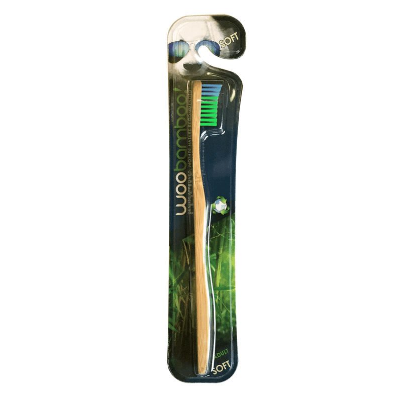 Woobamboo adult soft toothbrush with green bamboo handle and white bristles, designed for gentle oral cleaning.