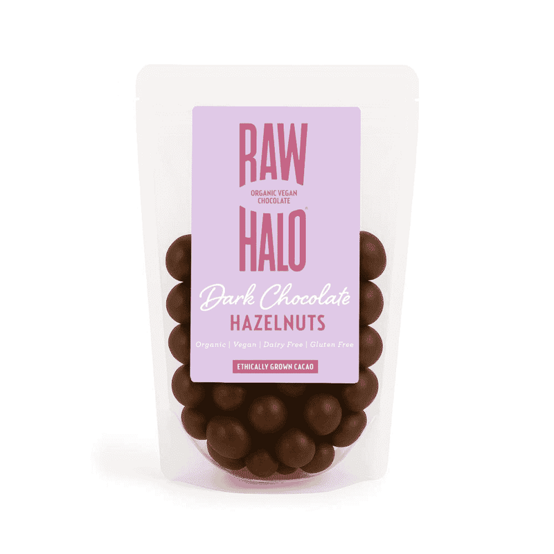 Raw Halo organic vegan dark chocolate hazelnuts in an 85g package, showcasing a mix of glossy dark chocolate and whole hazelnuts.