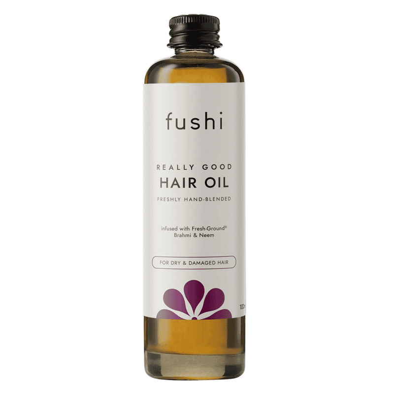 Fushi Really Good Hair Oil 100ml bottle with dropper cap and label, placed on a wooden surface.